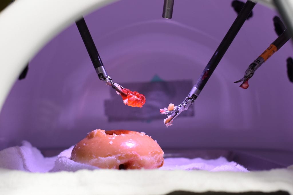 Dr. Roger Smith, Chief Technology Officer of the Nicholson Center at AdventHealth, demonstrated a robotic surgery operation on the da Vinci Xi, removing a gummy bear “tumor” from within a jelly-filled donut “patient.” Image credit: AdventHealth. 