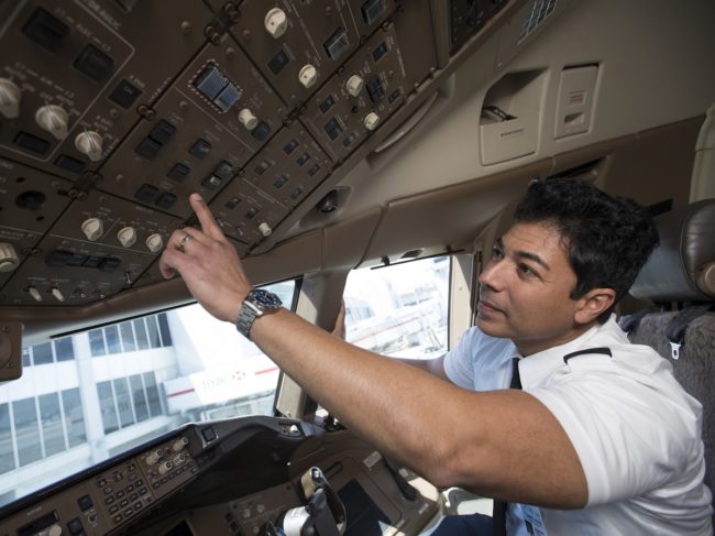 Pilots-working-the-controls-in-the-cockpit.jpg